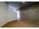 Spacious bedroom with exposed concrete wall and wood-look floors at 400 W Peachtree Nw St # 2314, Atlanta, GA 30308