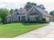 House exterior with a three-car garage and landscaped yard at 158 Watkins Glen Dr, Mcdonough, GA 30252