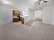Open concept kitchen and living area with wood cabinets and neutral carpet at 709 Celeste Sw Ln, Atlanta, GA 30331