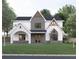 Two-story home features a stone and white exterior, a gabled roof, and landscaping at 474 Eastland Dr, Decatur, GA 30030