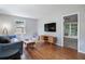 Living room with hardwood floors, comfy sofa, and a view to the sunroom at 873 Hearthstone Dr, Stone Mountain, GA 30083