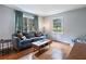 Living room with hardwood floors, blue sofa, and large windows at 873 Hearthstone Dr, Stone Mountain, GA 30083