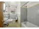 Clean bathroom with gray tile, a tub, and pedestal sink at 1272 Breezy Ne Ln, Atlanta, GA 30329