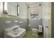 Bathroom with gray tile, a tub, and pedestal sink at 1272 Breezy Ne Ln, Atlanta, GA 30329