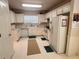 Galley-style kitchen with white cabinets, featuring a refrigerator, dishwasher, and microwave at 492 Mimosa Grove Xing, Tucker, GA 30084