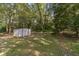White metal storage shed in a wooded backyard at 1645 Highpoint Rd, Snellville, GA 30078