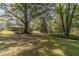 Large backyard with mature trees and green lawn at 1645 Highpoint Rd, Snellville, GA 30078