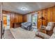 Living room with wood paneling, comfortable seating and access to patio at 1645 Highpoint Rd, Snellville, GA 30078