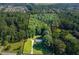 Aerial view of a house and property surrounded by lush trees at 4440 Stonewall Tell Rd, Atlanta, GA 30349