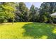 Spacious backyard with lush green grass and mature trees at 4440 Stonewall Tell Rd, Atlanta, GA 30349