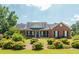 Brick house with a front porch, nicely landscaped lawn, and large windows at 12 Ivy Chase Nw Way, Cartersville, GA 30121