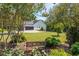 Landscaped backyard with a bench, lush greenery, and a view of the house and garage at 12 Ivy Chase Nw Way, Cartersville, GA 30121