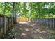 Small, fenced backyard with dirt ground and mature trees at 1666 Paddlewheel Dr, Marietta, GA 30062