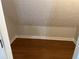 Small, sloped ceiling closet with hardwood flooring at 6209 Southland Forest Dr, Stone Mountain, GA 30087