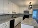 Renovated kitchen features granite countertops and white cabinets at 6209 Southland Forest Dr, Stone Mountain, GA 30087