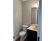 Small bathroom with toilet, sink, and dark vanity at 6209 Southland Forest Dr, Stone Mountain, GA 30087
