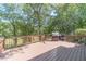 Large deck with built-in grill and tranquil wooded backdrop at 990 Bramlett Shoals Rd, Lawrenceville, GA 30045