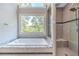 Bathroom featuring a soaking tub, walk-in shower, and large window at 990 Bramlett Shoals Rd, Lawrenceville, GA 30045