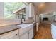 Kitchen features a farmhouse sink, granite countertops and white cabinetry at 990 Bramlett Shoals Rd, Lawrenceville, GA 30045
