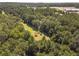 Aerial view showing home nestled in lush trees, with open areas nearby at 990 Bramlett Shoals Rd, Lawrenceville, GA 30045
