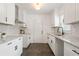 White kitchen with granite countertops and dark-colored tile floors at 1215 Richland Sw Rd, Atlanta, GA 30310