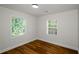 Well-lit bedroom featuring wood floors and two windows at 4244 Lindsey Dr, Decatur, GA 30035