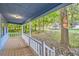 Front porch with wooden floor and white railing overlooking backyard at 34 Powder Brook Ct, Dallas, GA 30157