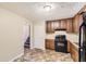 Galley kitchen with wood cabinets and black appliances at 34 Powder Brook Ct, Dallas, GA 30157