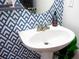 Chic bathroom with patterned wallpaper and pedestal sink at 9931 Mancunian Way, Douglasville, GA 30135