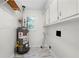Laundry room with built-in cabinets, water heater, and tiled floor at 3573 Clubhouse Ln, Conyers, GA 30094