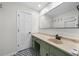 Bathroom with green vanity, large mirror, and patterned floor at 3573 Clubhouse Ln, Conyers, GA 30094