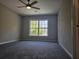 Spacious bedroom with large window, ceiling fan, and carpet at 2900 Brandford Trl, Locust Grove, GA 30248