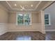 Bright dining room with wainscoting, hardwood floors, and a large window at 2900 Brandford Trl, Locust Grove, GA 30248