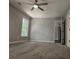 Well-lit bedroom with carpet, ceiling fan and access to hallway at 2900 Brandford Trl, Locust Grove, GA 30248