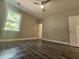 Spacious bedroom with hardwood floors, large window, and ceiling fan at 2900 Brandford Trl, Locust Grove, GA 30248