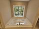 Soaking tub with a window overlooking the backyard at 2900 Brandford Trl, Locust Grove, GA 30248