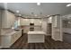 Open concept kitchen boasting white cabinets, island, and stainless steel appliances at 2900 Brandford Trl, Locust Grove, GA 30248