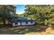 White ranch home with green metal roof, surrounded by trees at 2164 Five Points Rd, Waco, GA 30182