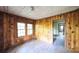 Simple living room with knotty pine walls and large windows at 2164 Five Points Rd, Waco, GA 30182