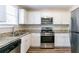 Kitchen with white cabinets, granite countertops, and stainless steel appliances at 416 Macedonia Se Rd, Atlanta, GA 30354