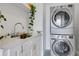 Bright laundry room with stacked washer and dryer, and a quartz countertop at 1065 Peachtree Ne St # 3003, Atlanta, GA 30309