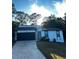 A house with a black garage door and white siding at 4907 Wycliffe Sw Dr, Stone Mountain, GA 30087