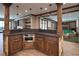 Basement bar with stone and wood finishes, and a view of a game room at 858 Middle Fork Trl, Suwanee, GA 30024