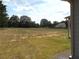 Large, grassy backyard with mature trees and a partially visible neighboring house at 689 S Jeff Davis Dr, Fayetteville, GA 30215