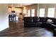 Open living room with a large sectional sofa, hardwood floors, and an adjacent kitchen at 689 S Jeff Davis Dr, Fayetteville, GA 30215