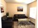 Living Room with dark leather sofas, a mirrored coffee table, and an area rug at 689 S Jeff Davis Dr, Fayetteville, GA 30215