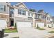 Row of townhouses with attached garages and landscaping at 174 Hampton Cir, Mcdonough, GA 30253
