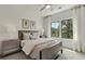 Bright bedroom with large windows, wooden bed frame, and neutral decor at 1094 Battery Park Rd, Decatur, GA 30033