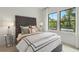 Cozy bedroom with a tufted headboard, neutral bedding, and large windows at 1096 Battery Park Rd, Decatur, GA 30033