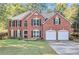 Brick house with two car garage and a manicured lawn at 2049 Town Square Dr, Mcdonough, GA 30253